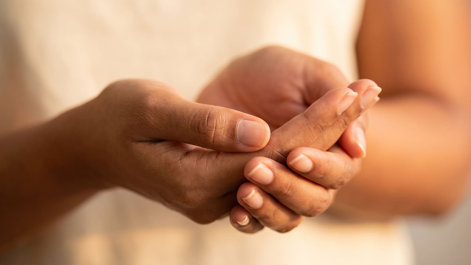 Cupped hands in warm light, a symbol of careful, expert skin care