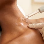 Hydrafacial treatment wand gliding over the neck and collarbone skin